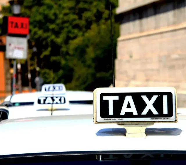 Mehrere Taxis in Italien, bereit, Touristen zu befördern. Die Taxi Kosten in Italien können je nach Stadt und Tageszeit variieren.