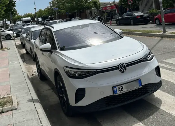 Weißer VW ID.4 mit albanischem Kennzeichen, bereit für seine nächste Fahrt als Taxi in Albanien.